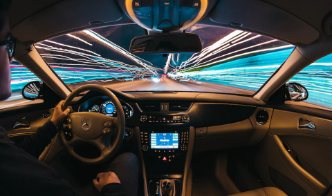 Person driving car with streaks of light on both sides